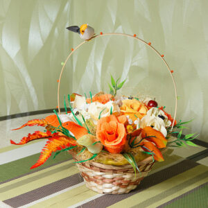 Artificial flowers with candy in a basket on the table